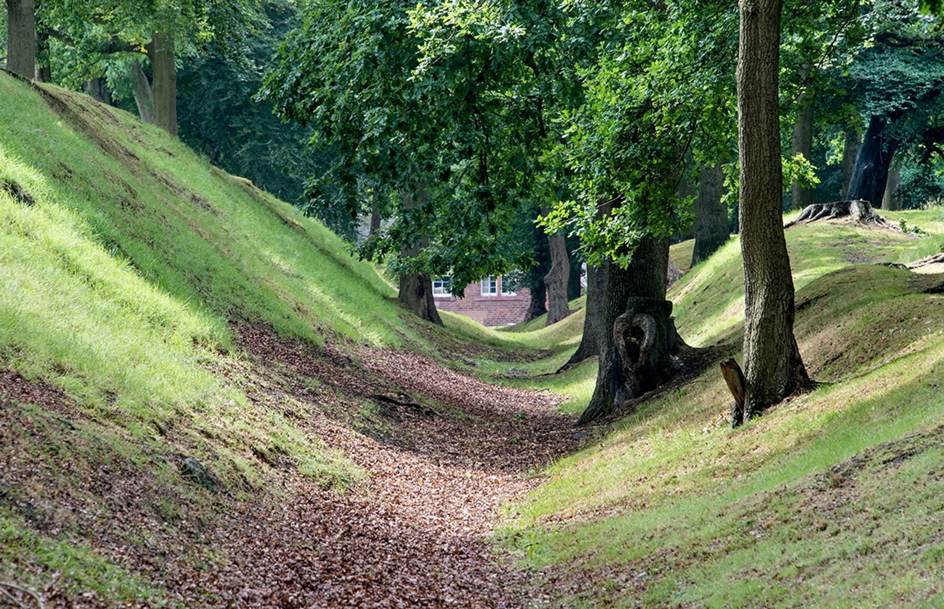 © Crown Copyright HES. Watling Lodge, a steep bank on the right with a leaf strewn ditch below, a lower bank to the left and trees on either side. © Crown Copyright HES. Watling Lodge, a steep bank on the right with a leaf strewn ditch below, a lower bank to the left and trees on either side.