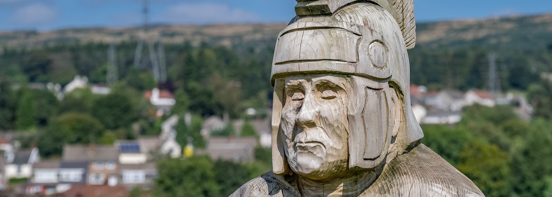 © Rediscovering the Antonine Wall Project
A wooden Roman soldier sculpture at Duntocher Play Park. It is sunny and there are houses and trees behind it. © Rediscovering the Antonine Wall Project
A wooden Roman soldier sculpture at Duntocher Play Park. It is sunny and there are houses and trees behind it.