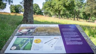 © Rediscovering the Antonine Wall Project
Seabegs Wood, a white and purple interpretation panel on a low stone plinth with grass, trees, and sky in the background. © Rediscovering the Antonine Wall Project
Seabegs Wood, a white and purple interpretation panel on a low stone plinth with grass, trees, and sky in the background.