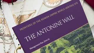 © Crown Copyright HES
A close-up of a person holding the Antonine Wall Management Plan 2014-2019, they are wearing a Roman Centurion costume. © Crown Copyright HES
A close-up of a person holding the Antonine Wall Management Plan 2014-2019, they are wearing a Roman Centurion costume.