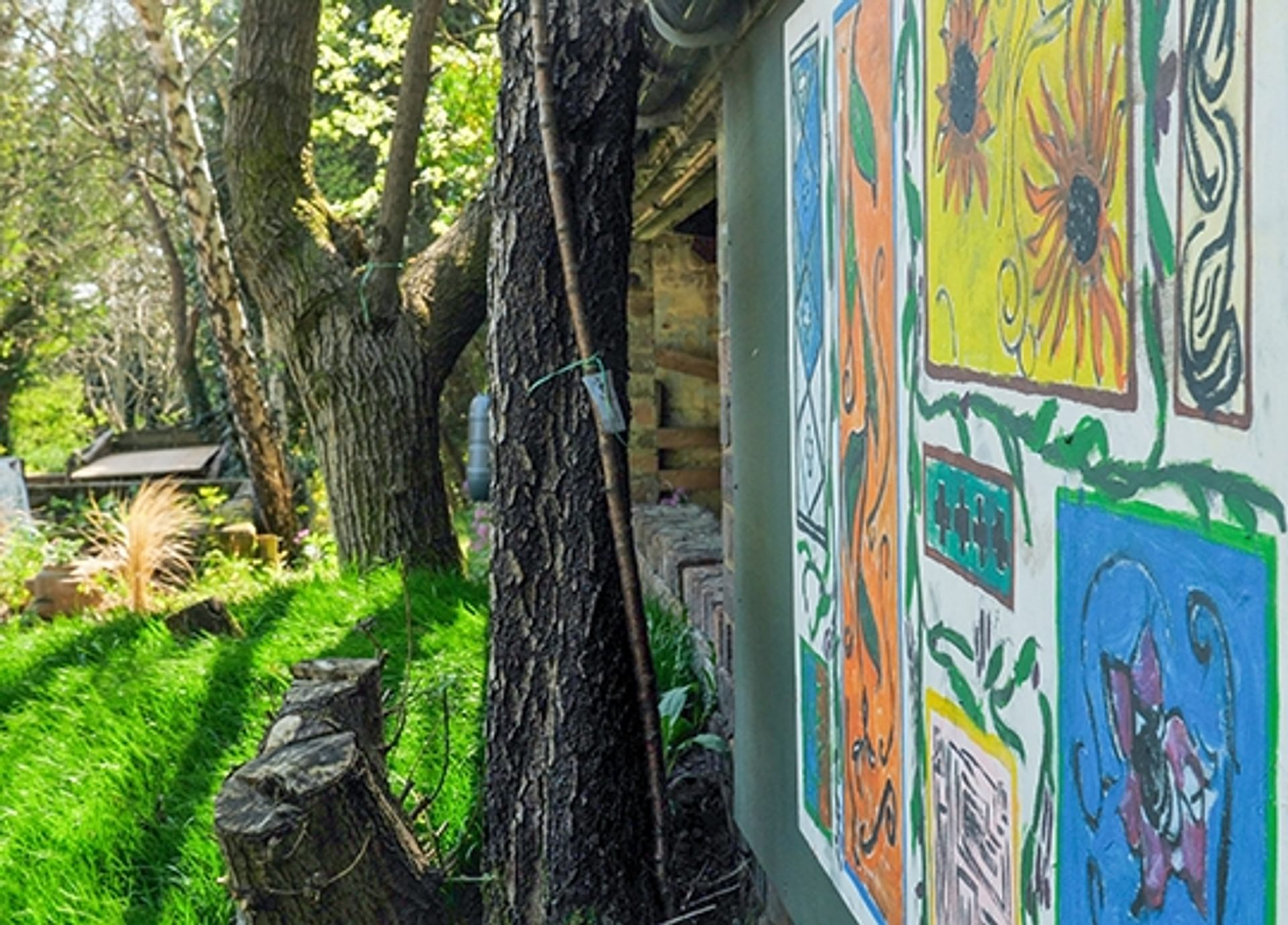 © Rediscovering the Antonine Wall Project
Bearsden Baptist Church garden. A panel with colourful illustrations of Roman plants on a blue wall, trees, and plants beyond. © Rediscovering the Antonine Wall Project
Bearsden Baptist Church garden. A panel with colourful illustrations of Roman plants on a blue wall, trees, and plants beyond.