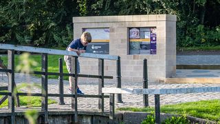 © Rediscovering the Antonine Wall Project
Old Kilpatrick, a boy stands on a bridge looking at the canal below him. The replica distance stone and trees behind him. © Rediscovering the Antonine Wall Project
Old Kilpatrick, a boy stands on a bridge looking at the canal below him. The replica distance stone and trees behind him.
