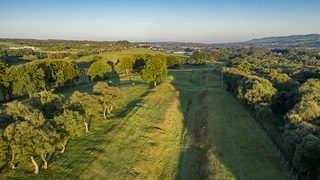 © Rediscovering the Antonine Wall Project
Rough Castle from above, the wall and ditch still visible as steep grassy mounds running along a wide path between the trees. © Rediscovering the Antonine Wall Project
Rough Castle from above, the wall and ditch still visible as steep grassy mounds running along a wide path between the trees.