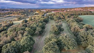 © Rediscovering the Antonine Wall Project
Seabegs Wood from above. The site is marked by wide grass paths through the woods. There are houses and dark blue sky beyond. © Rediscovering the Antonine Wall Project
Seabegs Wood from above. The site is marked by wide grass paths through the woods. There are houses and dark blue sky beyond.