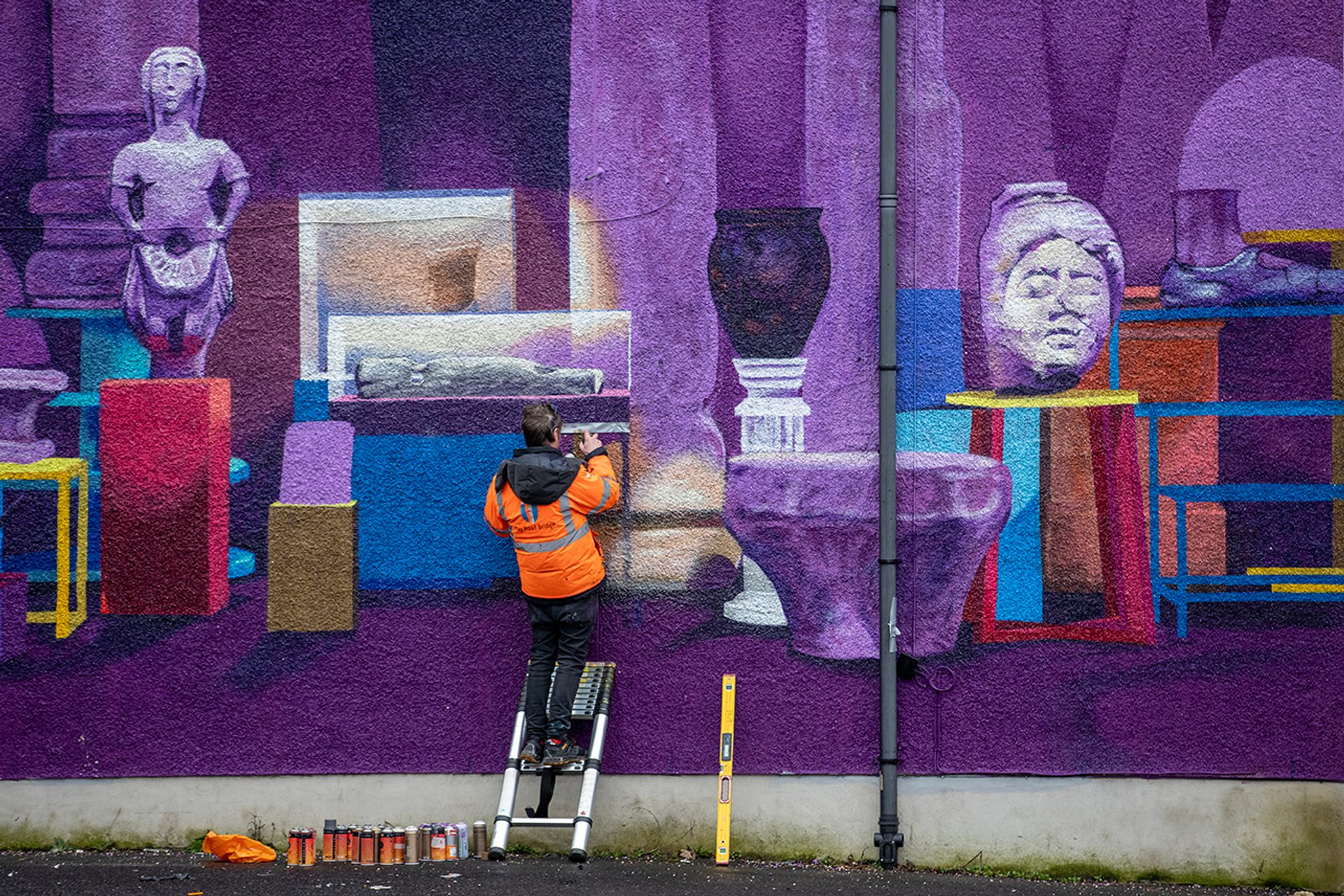 Image of man painting a purple mural Image of man painting a purple mural