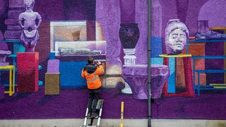 Image of man painting a purple mural Image of man painting a purple mural