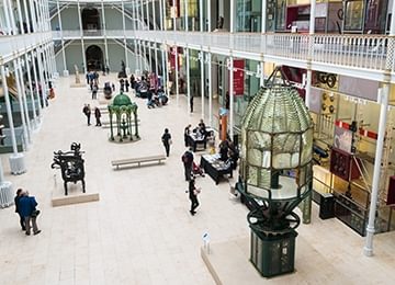 © Historic Environment Scotland.
National Museum of Scotland, Grand Gallery from above. A large hall with white floor. Columns support balconies either side. © Historic Environment Scotland.
National Museum of Scotland, Grand Gallery from above. A large hall with white floor. Columns support balconies either side.