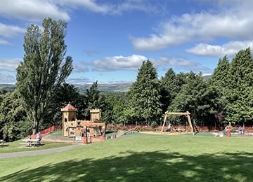 © Rediscovering the Antonine Wall Project
Peel Park, Kirkintilloch. A Roman themed play park. Trees lie behind the park and Kirkintilloch behind them. © Rediscovering the Antonine Wall Project
Peel Park, Kirkintilloch. A Roman themed play park. Trees lie behind the park and Kirkintilloch behind them.